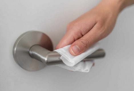 Coronavirus Covid 19 Prevention Cleaning Woman Wiping Doorknob With Antibacterial Disinfecting Wipe For Killing Corona Virus On Touching Surfaces Or Touching Public Bathroom Handle With Tissue.
